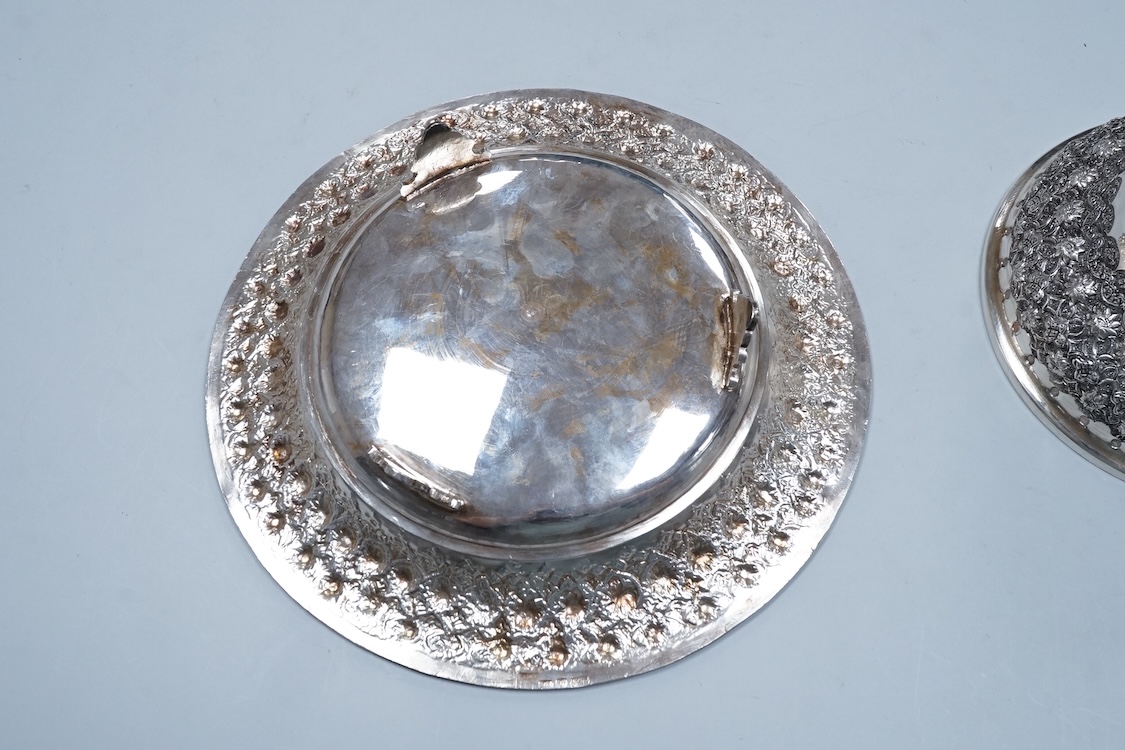 A 20th century Middle Eastern white metal circular dish and cover, embossed with flower heads, stamped '84', base diameter 24.2cm, 28.2oz.